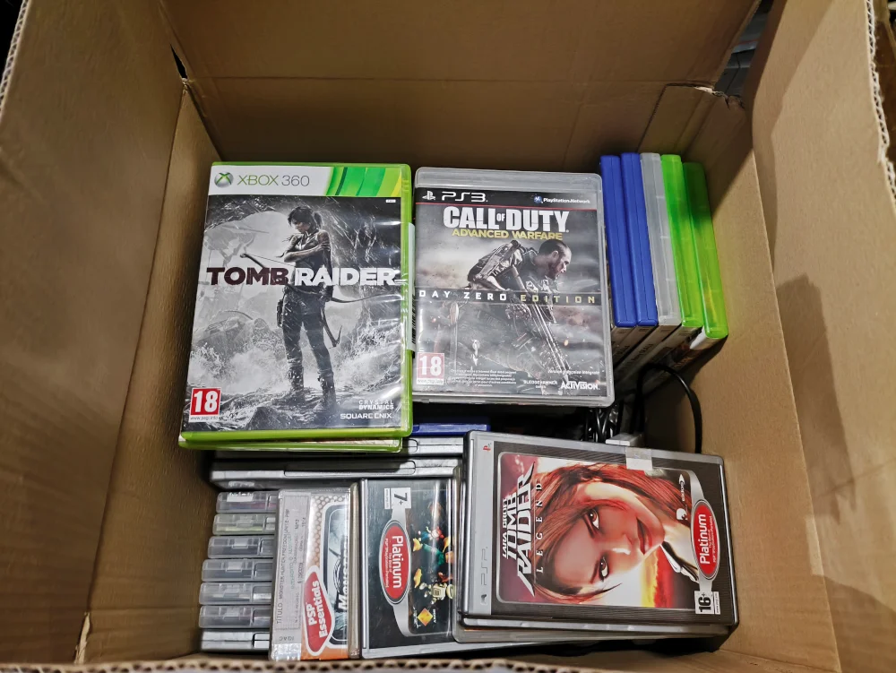 Caixa com jogos usados de várias consolas
